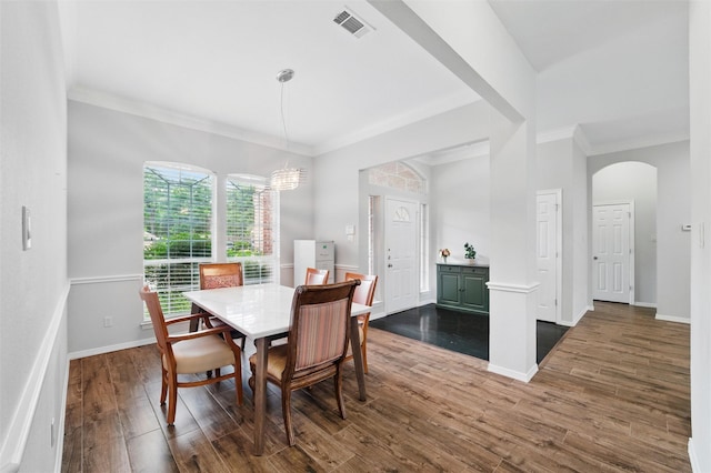 3402 Blue Forest Dr, Arlington, TX 76001 - dining area featuring crown molding, dark wood-type flooring, baseboards, arched walkways, and a chandelier