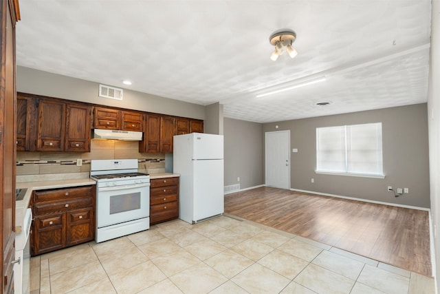2363 Talco Dr, Dallas, TX 75241 - kitchen featuring white appliances, under cabinet range hood, light countertops, tasteful backsplash, and baseboards