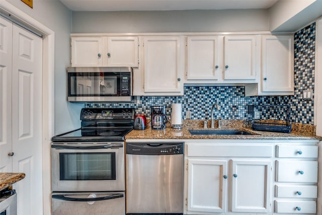 4902 N Hall St, Dallas, TX 75235 - kitchen with appliances with stainless steel finishes, a sink, white cabinets, and tasteful backsplash