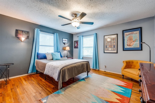 4902 N Hall St, Dallas, TX 75235 - bedroom featuring light wood-style floors, a textured ceiling, baseboards, and ceiling fan
