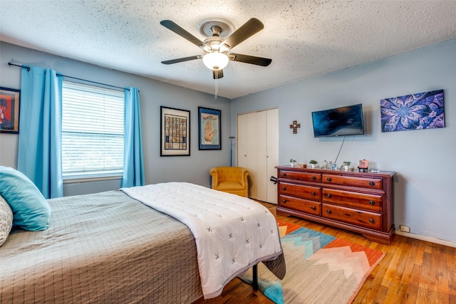 4902 N Hall St, Dallas, TX 75235 - bedroom with a closet, wood-type flooring, a ceiling fan, a textured ceiling, and baseboards