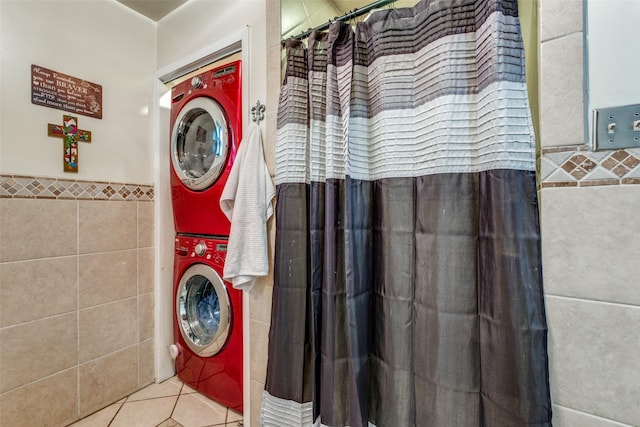 4902 N Hall St, Dallas, TX 75235 - laundry area featuring tile walls, estacked washer and dryer, tile patterned flooring, and wainscoting