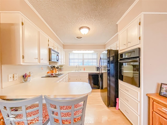 2850 Button Willow Ave, Abilene, TX 79606 - kitchen featuring black appliances, a sink, a textured ceiling, a peninsula, and light countertops