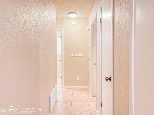 2850 Button Willow Ave, Abilene, TX 79606 - hallway featuring a textured wall, light tile patterned flooring, and a textured ceiling