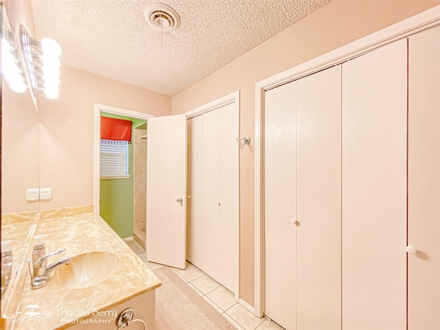2850 Button Willow Ave, Abilene, TX 79606 - full bath featuring vanity, a textured ceiling, tile patterned floors, and a shower