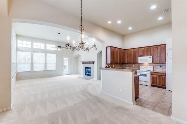 1728 Sandpiper Ln, Carrollton, TX 75007 - kitchen with white appliances, arched walkways, a towering ceiling, light colored carpet, and open floor plan