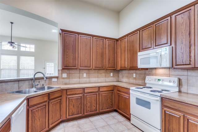 1728 Sandpiper Ln, Carrollton, TX 75007 - kitchen featuring white appliances, a sink, tasteful backsplash, and brown cabinets