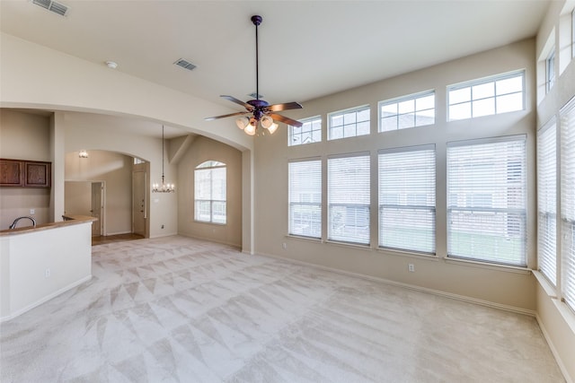 1728 Sandpiper Ln, Carrollton, TX 75007 - unfurnished living room with light carpet, arched walkways, ceiling fan, a chandelier, and baseboards