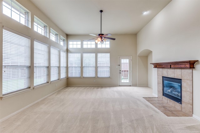 1728 Sandpiper Ln, Carrollton, TX 75007 - unfurnished living room with a ceiling fan, carpet flooring, a tile fireplace, baseboards, and a towering ceiling