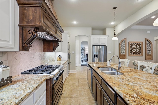 3500 Oak Island Ln, Flower Mound, TX 75028 - kitchen featuring arched walkways, a sink, appliances with stainless steel finishes, tasteful backsplash, and white cabinets