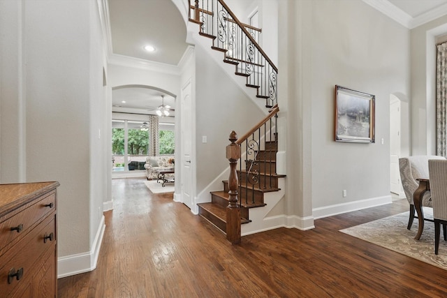 3500 Oak Island Ln, Flower Mound, TX 75028 - entrance foyer with arched walkways, ornamental molding, a ceiling fan, dark wood-type flooring, and stairway