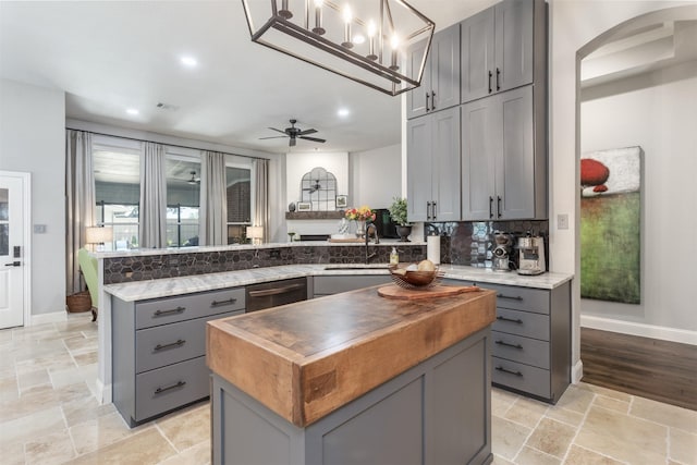 507 Clover Leaf Ln, Mckinney, TX 75072 - kitchen featuring gray cabinets, butcher block countertops, a sink, a peninsula, and a center island