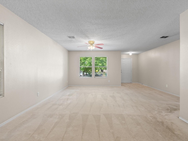 7605 Mosspoint Ct, Denton, TX 76210 - unfurnished room with light colored carpet, ceiling fan, baseboards, and a textured ceiling