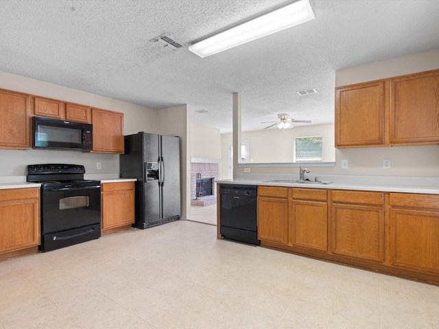 7605 Mosspoint Ct, Denton, TX 76210 - kitchen featuring black appliances, a sink, brown cabinets, light countertops, and a textured ceiling