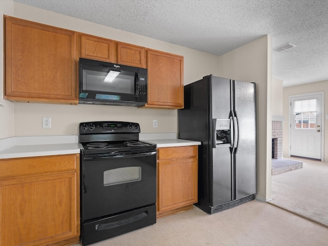 7605 Mosspoint Ct, Denton, TX 76210 - kitchen with black appliances, light countertops, a textured ceiling, brown cabinets, and light carpet