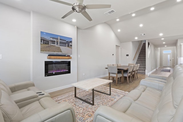 2012 Edgewater St, Celina, TX 75009 - living room featuring stairs, baseboards, light wood-style flooring, recessed lighting, and a glass covered fireplace