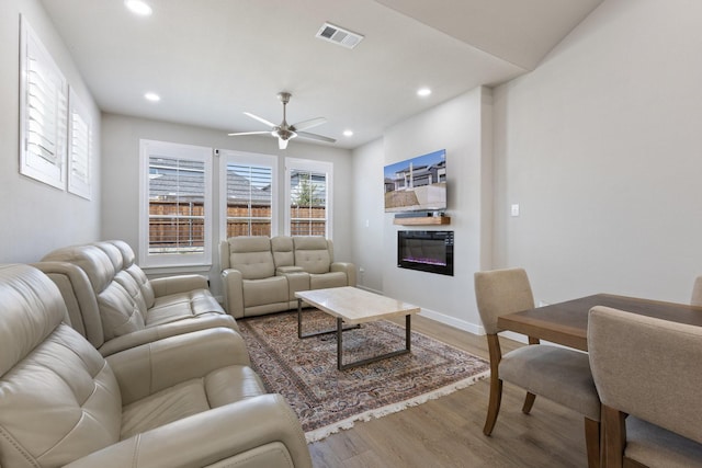 2012 Edgewater St, Celina, TX 75009 - living area with wood finished floors, a glass covered fireplace, recessed lighting, ceiling fan, and baseboards