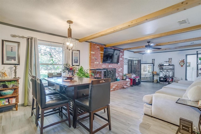 905 E Renfro St, Burleson, TX 76028 - dining space with beamed ceiling, a chandelier, a fireplace, a ceiling fan, and light wood-type flooring