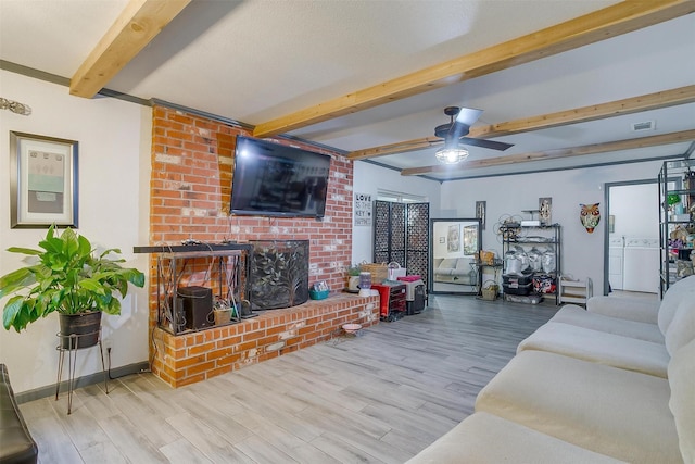 905 E Renfro St, Burleson, TX 76028 - living area with independent washer and dryer, beamed ceiling, wood finished floors, ceiling fan, and a brick fireplace
