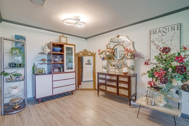 905 E Renfro St, Burleson, TX 76028 - sitting room with light wood-style floors, ornamental molding, and a textured ceiling
