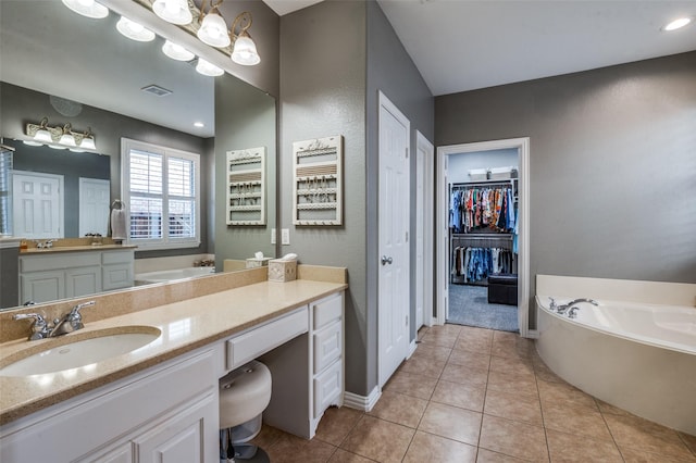 7201 Faraday Ln, Mckinney, TX 75071 - bathroom with a garden tub, vanity, tile patterned flooring, a walk in closet, and baseboards