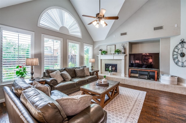 7201 Faraday Ln, Mckinney, TX 75071 - living room featuring wood finished floors, healthy amount of natural light, ceiling fan, a tiled fireplace, and high vaulted ceiling