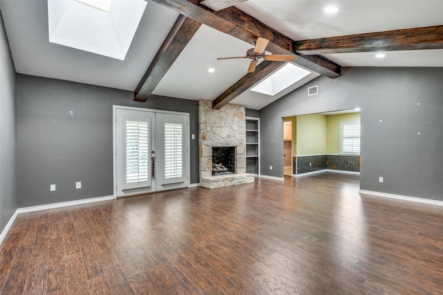 10118 Cromwell Dr, Dallas, TX 75229 - unfurnished living room featuring a skylight, ceiling fan, plenty of natural light, and a fireplace