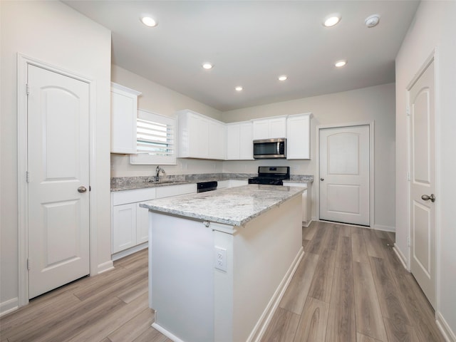 1218 Parker Dr, Princeton, TX 75407 - kitchen featuring appliances with stainless steel finishes, light wood-style flooring, white cabinetry, and recessed lighting