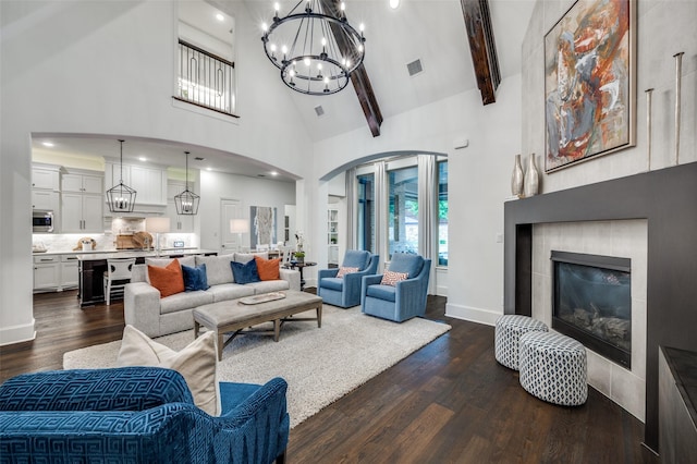 2021 Longmont Ln, Prosper, TX 75078 - living room featuring high vaulted ceiling, a tile fireplace, a chandelier, dark wood-style flooring, and beam ceiling