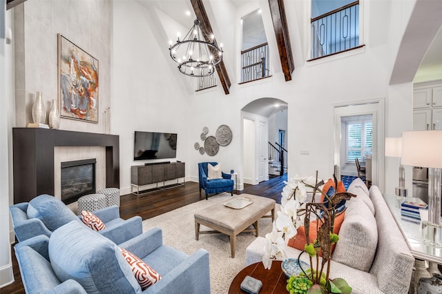 2021 Longmont Ln, Prosper, TX 75078 - living area with arched walkways, high vaulted ceiling, dark wood-style flooring, stairs, and a chandelier