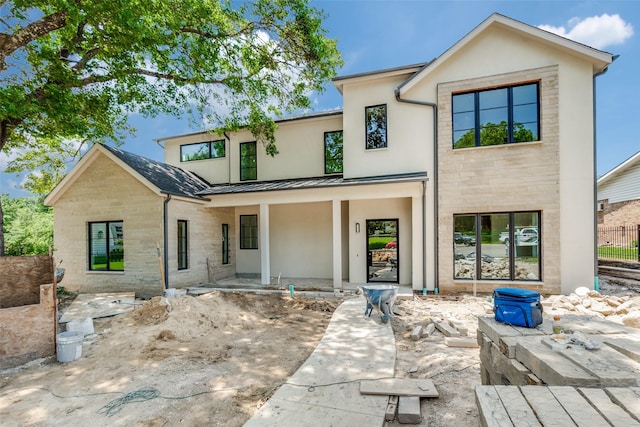 7163 Lyre Ln, Dallas, TX 75214 - view of front of house featuring a standing seam roof, stone siding, metal roof, and a porch