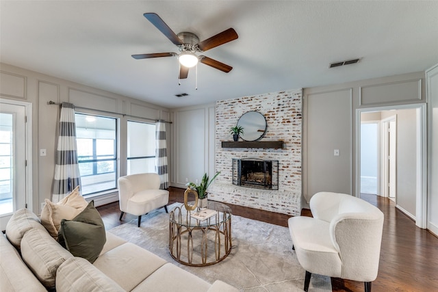 5004 Andover Dr, Plano, TX 75023 - living room featuring a decorative wall, a ceiling fan, a brick fireplace, and wood finished floors