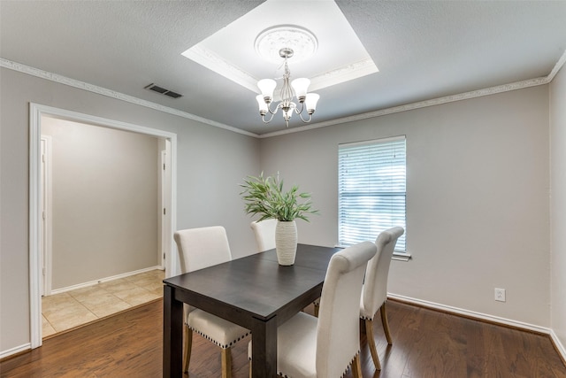 5004 Andover Dr, Plano, TX 75023 - dining space with a chandelier, wood finished floors, a tray ceiling, and crown molding