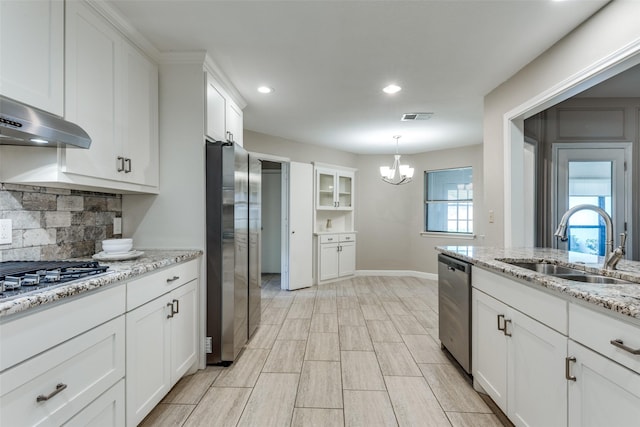 5004 Andover Dr, Plano, TX 75023 - kitchen with stainless steel appliances, a chandelier, white cabinets, tasteful backsplash, and range hood