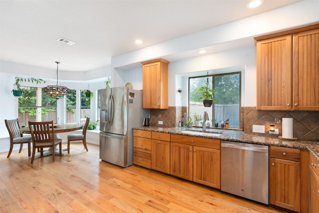933 Oatlands Pl, Burleson, TX 76028 - kitchen with appliances with stainless steel finishes, plenty of natural light, light wood-type flooring, dark stone counters, and recessed lighting