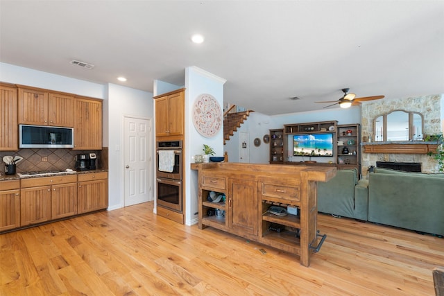 933 Oatlands Pl, Burleson, TX 76028 - kitchen featuring appliances with stainless steel finishes, ceiling fan, light wood-style floors, decorative backsplash, and recessed lighting