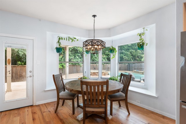 933 Oatlands Pl, Burleson, TX 76028 - dining room with a chandelier, light wood finished floors, and baseboards