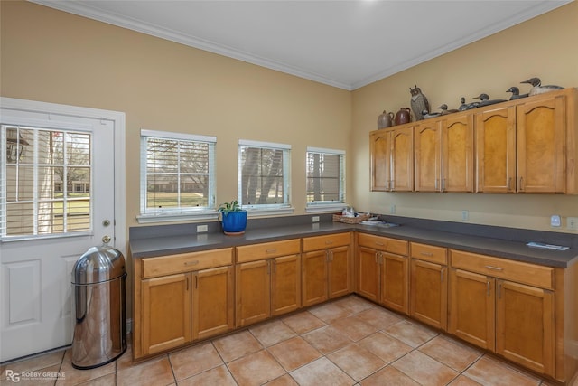 5705 Lake Side Dr, Bossier City, LA 71111 - kitchen featuring light tile patterned floors, dark countertops, brown cabinetry, and ornamental molding