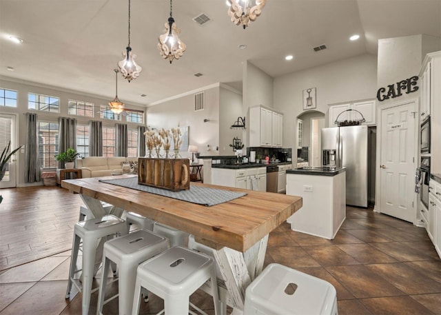 2541 Sir Tristram Ln, Lewisville, TX 75056 - dining area with plenty of natural light, recessed lighting, arched walkways, crown molding, and dark tile patterned floors