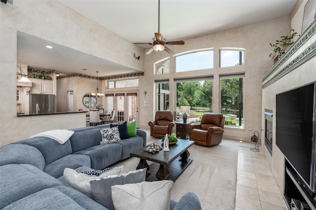3873 Heritage Trl, Celina, TX 75009 - living room with a chandelier, a high ceiling, a ceiling fan, recessed lighting, and light tile patterned flooring
