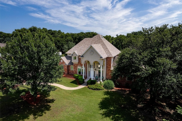 3873 Heritage Trl, Celina, TX 75009 - french country style house featuring a front lawn, brick siding, and roof with shingles