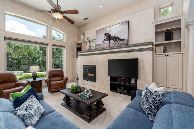 3873 Heritage Trl, Celina, TX 75009 - living room with ceiling fan, built in features, a fireplace, and a high ceiling