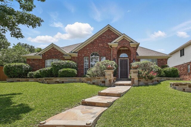 8217 Alderwood Pl, Plano, TX 75025 - view of front of house featuring brick siding, a front lawn, and roof with shingles