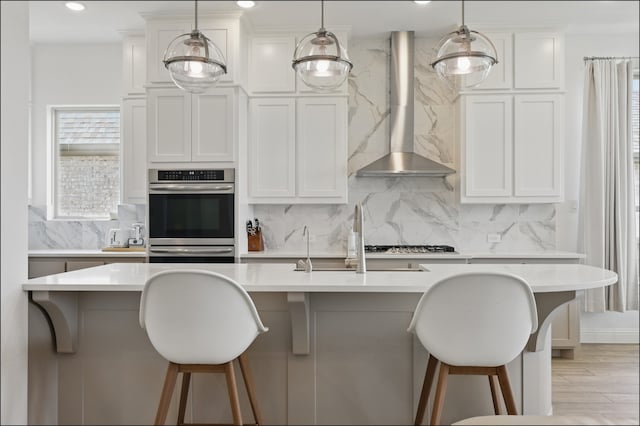1001 Gentle Knoll Ln, Prosper, TX 75078 - kitchen with double oven, wall chimney exhaust hood, light countertops, decorative backsplash, and recessed lighting
