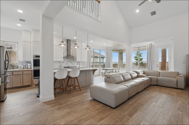 1001 Gentle Knoll Ln, Prosper, TX 75078 - living area with light wood finished floors, a ceiling fan, high vaulted ceiling, and recessed lighting