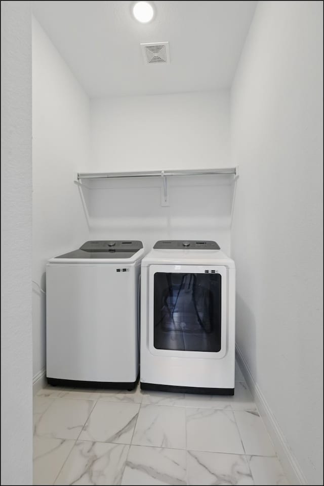 1001 Gentle Knoll Ln, Prosper, TX 75078 - washroom with washing machine and clothes dryer, baseboards, and light marble finish floors