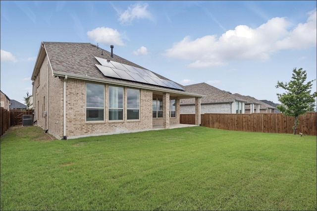 1001 Gentle Knoll Ln, Prosper, TX 75078 - back of property featuring central air condition unit, roof mounted solar panels, brick siding, a patio, and roof with shingles