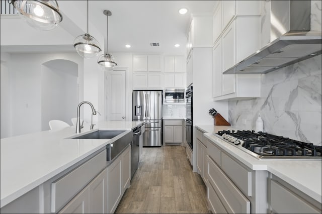 1001 Gentle Knoll Ln, Prosper, TX 75078 - kitchen featuring stainless steel appliances, wall chimney exhaust hood, a sink, light countertops, and recessed lighting
