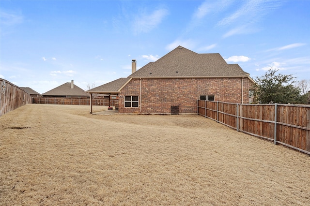 2408 Comal Ct, Royse City, TX 75189 - back of house featuring brick siding, a fenced backyard, a shingled roof, a patio, and a chimney