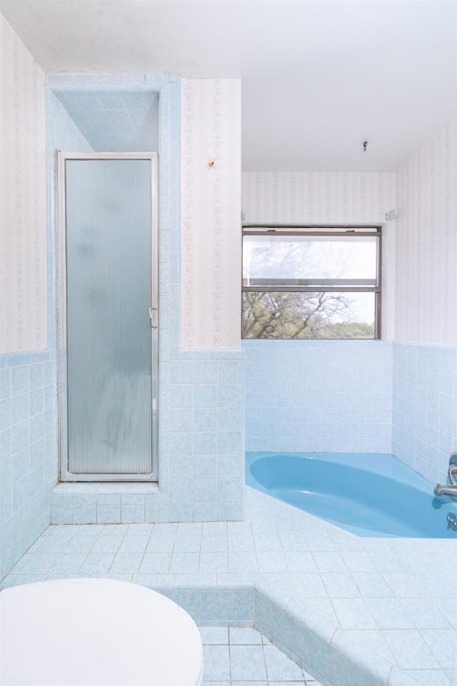 2992 County Road 100, Brady, TX 76825 - bathroom with wallpapered walls, tile walls, a bath, a shower stall, and wainscoting
